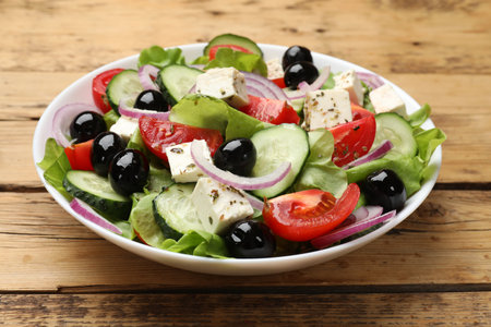 Delicious salad with feta cheese on wooden table, closeupの写真素材