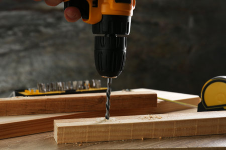 Drilling hole in plank on wooden table, closeupの写真素材