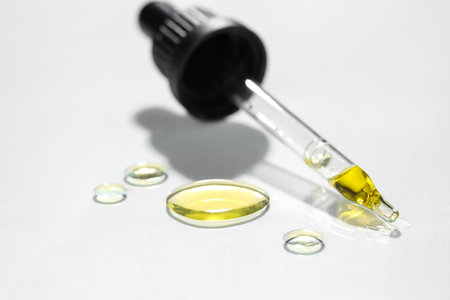 Cosmetic oil and pipette on light gray background, closeupの写真素材