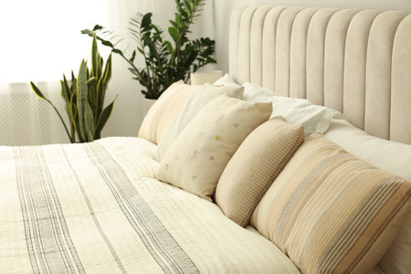Large bed and houseplants in stylish room