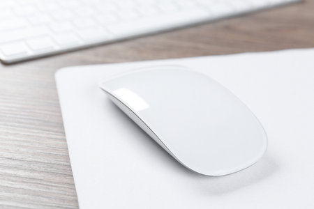 Computer mouse with mousepad and keyboard on wooden desk, closeupの写真素材