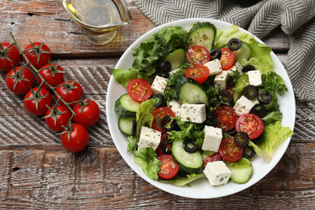 Delicious salad with feta cheese on wooden table, flat layの写真素材