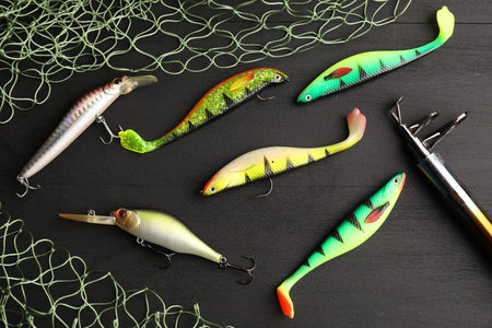 Fishing tackles, rod and net on gray wooden table, flat lay
