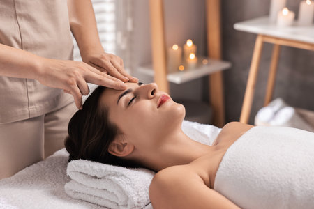 Attractive woman enjoying face massage in spa salon, closeupの写真素材