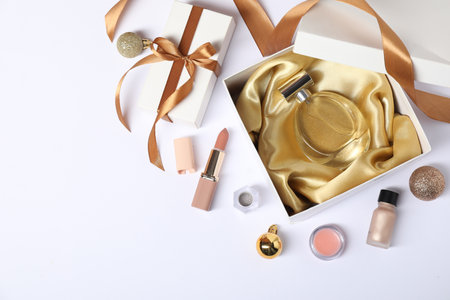 Christmas composition with perfume bottle and cosmetic products on white background, flat lay. Space for textの写真素材