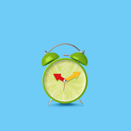 Juicy lime on alarm clock dial against light blue background. Creative posterの写真素材