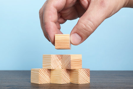 Woman with wooden cubes at table, closeupの写真素材
