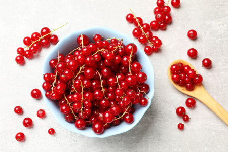 Fresh red currents on light gray table, flat lay
