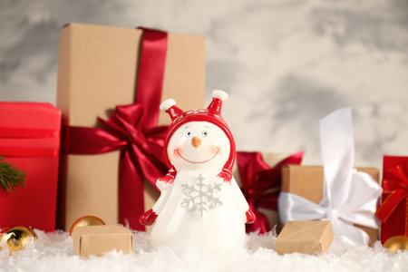 Funny snowman figure and Christmas decor on artificial snowの写真素材