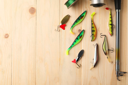 Fishing rod, tackles and line on wooden table, flat lay. Space for textの写真素材