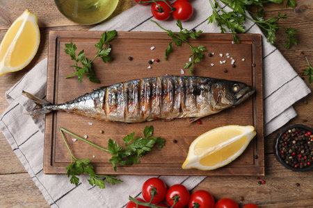 Delicious grilled mackerel, parsley, spices, tomatoes and lemon on wooden table, flat layの写真素材