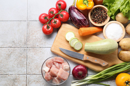 Uncooked ingredients for stew on tiled table, flat layの写真素材