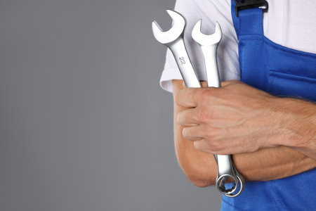 Auto mechanic with wrenches on gray background, closeup. Space for textの写真素材