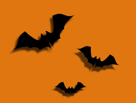 Three black bats flying on orange background. Halloween celebrationの写真素材