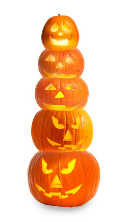 Stack of pumpkins with carved spooky faces on white background. Halloween jack-o-lanterns of different sizesの写真素材