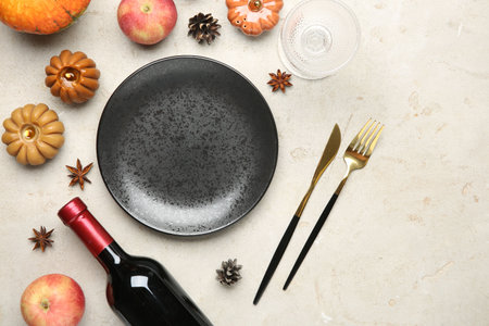 Stylish place setting, bottle of wine and autumn decor on gray textured table. Space for textの写真素材