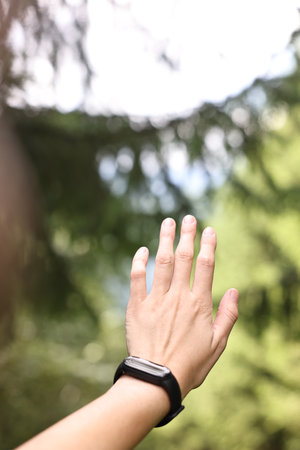 Young hiker with wristwatch, closeup. Space for text