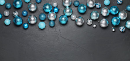 Different Christmas balls on gray textured background, flat lay. Space for text