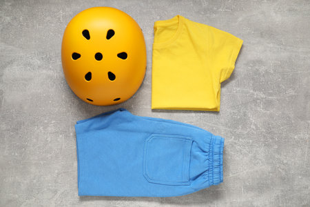 Bicycle helmet and sportswear on light gray textured background, flat layの写真素材
