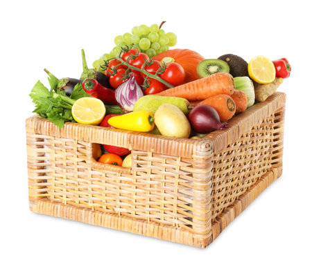Different fresh fruits and vegetables in wicker basket isolated on whiteの写真素材