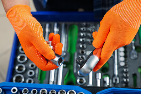 Auto mechanic with torque wrench and different tools at automobile repair shop, top viewの写真素材