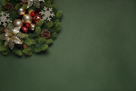Christmas wreath with cones, baubles and decorative snowflakes on green background, top view. Space for textの写真素材