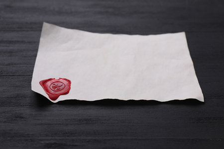 Old letter with wax stamp on black wooden table, closeupの写真素材