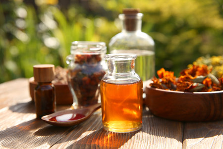 Different tinctures and ingredients on wooden table outdoorsの写真素材