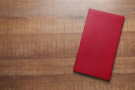 Hardcover book on wooden table, top view. Space for textの写真素材