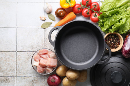 Uncooked ingredients for stew on tiled table, flat layの写真素材