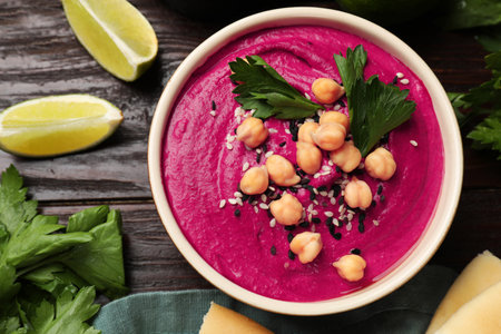 Tasty beetroot hummus in bowl and products on wooden table, flat layの写真素材