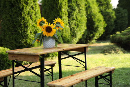 Vase with sunflowers on wooden table in gardenの写真素材