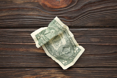 One crumpled dollar banknote on wooden table, top viewの写真素材