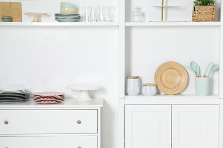White shelving unit with different kitchenware indoorsの写真素材