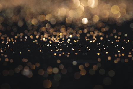 Beautiful shiny golden glitter on black background, closeupの写真素材