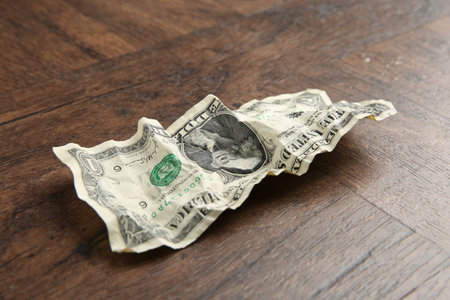 One crumpled dollar banknote on wooden table, closeupの写真素材
