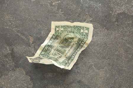 One crumpled dollar banknote on gray table, top viewの写真素材