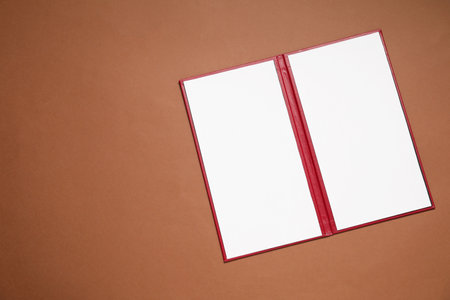 Hardcover notebook with blank sheets on brown background, top view. Mockup for design