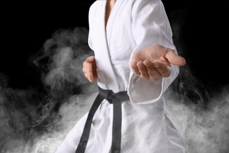 Karate fighter in smoke on black background, closeupの写真素材