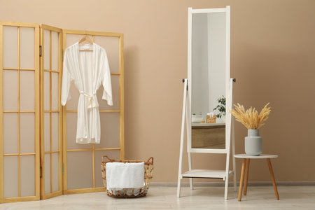 Large mirror near beige wall in bathroom. Interior design