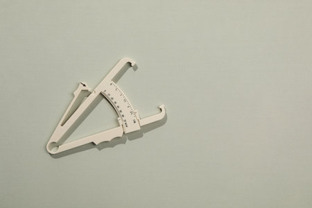 Plastic body fat caliper on gray background, top view. Space for textの写真素材