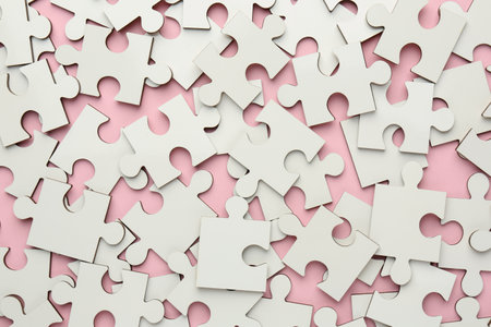 White puzzle pieces on pink background, top viewの写真素材
