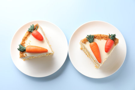 Pieces of delicious carrot cake on light blue background, top viewの写真素材
