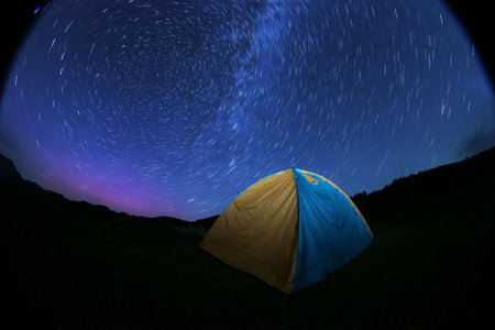 Modern camping tent in wilderness at night. Fisheye lens effectの写真素材