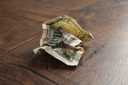 One crumpled dollar banknote on wooden table, closeupの写真素材