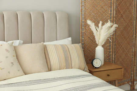 Large bed, folding screen and bedside table in stylish room