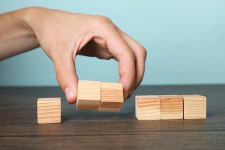 Woman holding wooden cubes at table, closeupの写真素材
