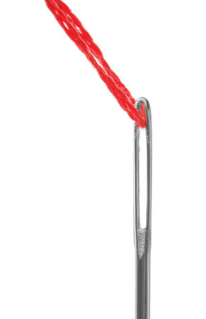 Sewing needle with red thread isolated on white, closeup