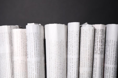 Many newspapers in different languages on gray background, closeupの写真素材