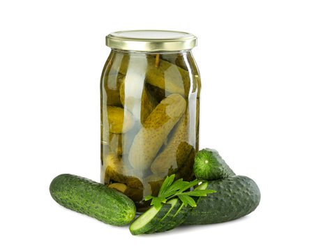 Tasty pickled cucumbers in jar, fresh vegetables and parsley isolated on whiteの写真素材